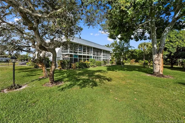 a view of a house with a big yard and large trees