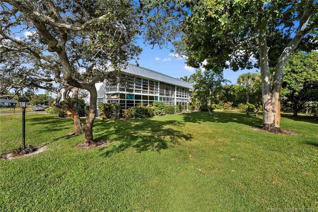 2929 Southeast Ocean Boulevard, Unit 1397 Stuart, FL 34996 - Photo 29 of 38 a view of a house with a big yard and large trees