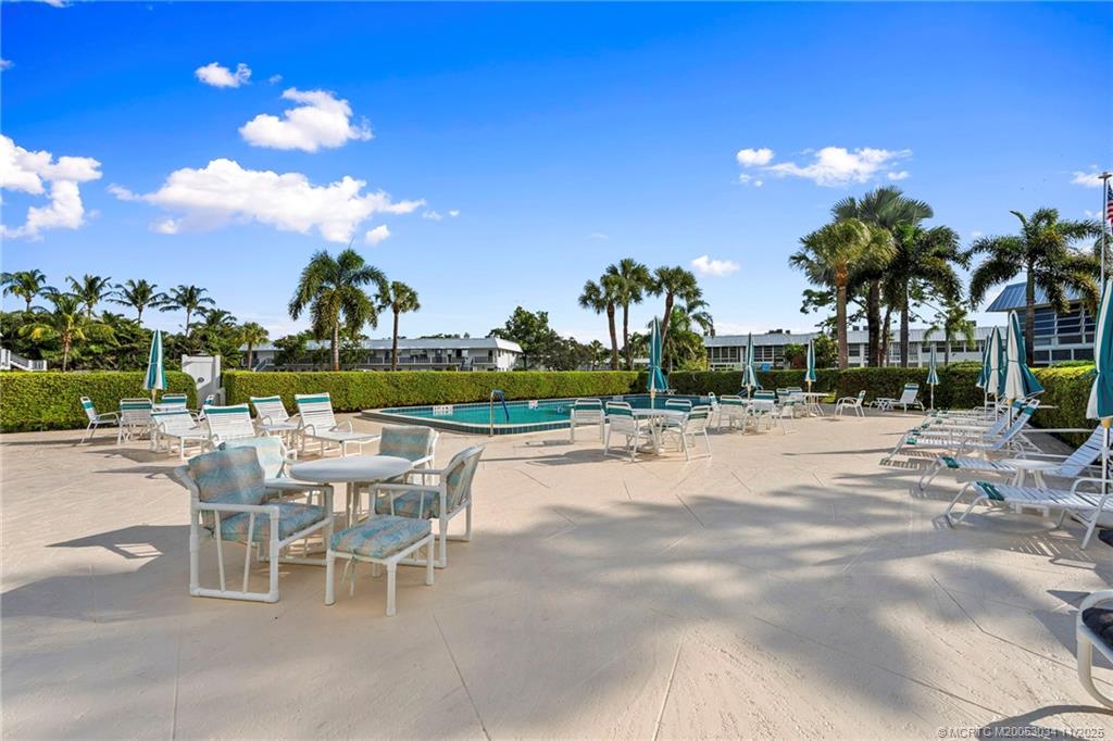 2929 Southeast Ocean Boulevard, Unit 1397 Stuart, FL 34996 - Photo 34 of 38 a view of a swimming pool and outdoor seating