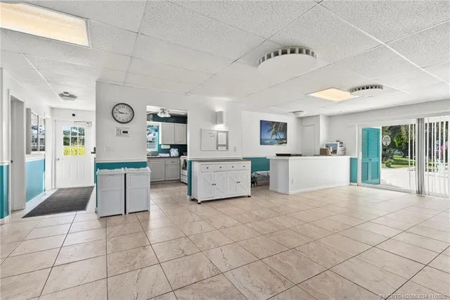 a large white kitchen with a stove a sink dishwasher and a refrigerator with white cabinets
