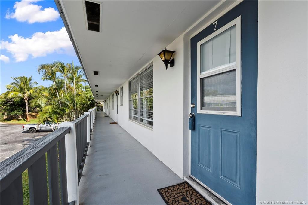 2929 Southeast Ocean Boulevard, Unit 1397 Stuart, FL 34996 - Photo 4 of 38 a hallway with wooden floor and potted plant