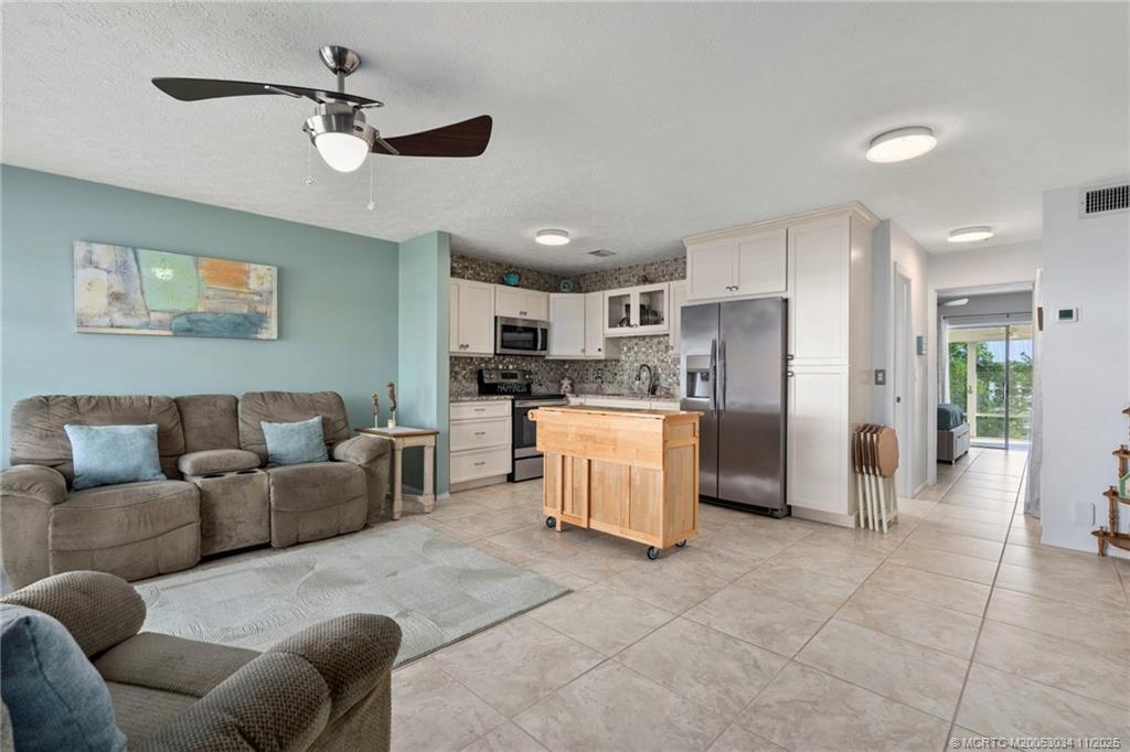 2929 Southeast Ocean Boulevard, Unit 1397 Stuart, FL 34996 - Photo 7 of 38 a living room with furniture and kitchen view