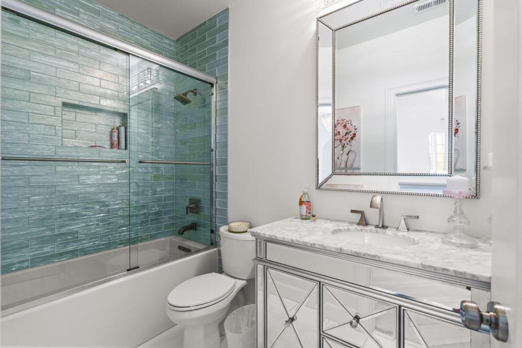 515 Tullamore Way Alpharetta, GA 30004 - Photo 26 of 71 a bathroom with a granite countertop toilet a sink and a mirror
