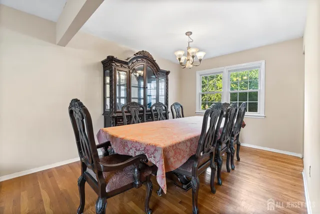 a view of a dining room with furniture a chandelier and wooden floor