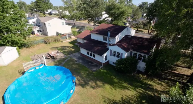 a view of a swimming pool with a bench and trees in the background