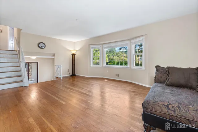 a view of a bedroom with wooden floor and window