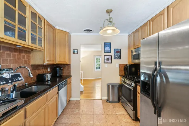 a kitchen with stainless steel appliances a refrigerator a sink a stove and cabinets