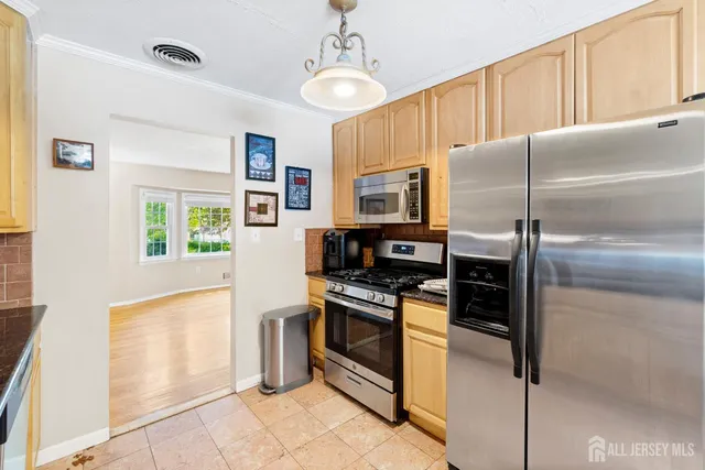 a kitchen with granite countertop a refrigerator and a stove top oven