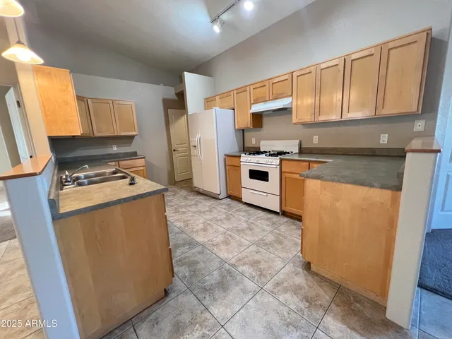 a kitchen with stainless steel appliances granite countertop a refrigerator stove sink and dishwasher