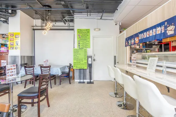 a dining room with stainless steel appliances kitchen island granite countertop a table and chairs in it
