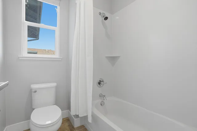 a view of a street with a houses in back