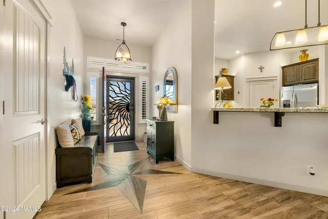 a view of a hallway with wooden floor and windows