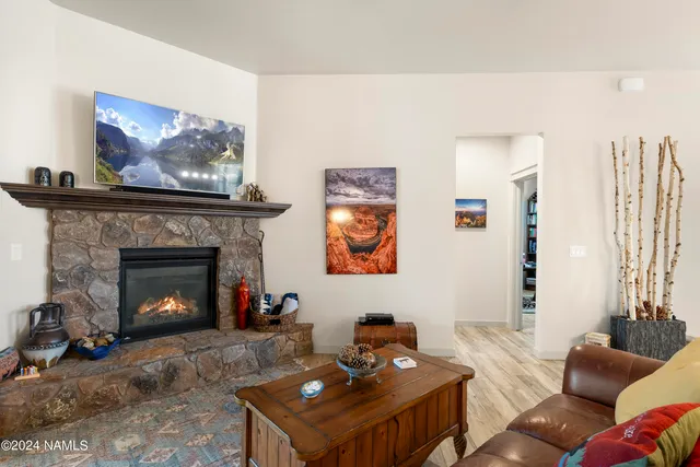 a living room with furniture a fireplace and paintings on the wall