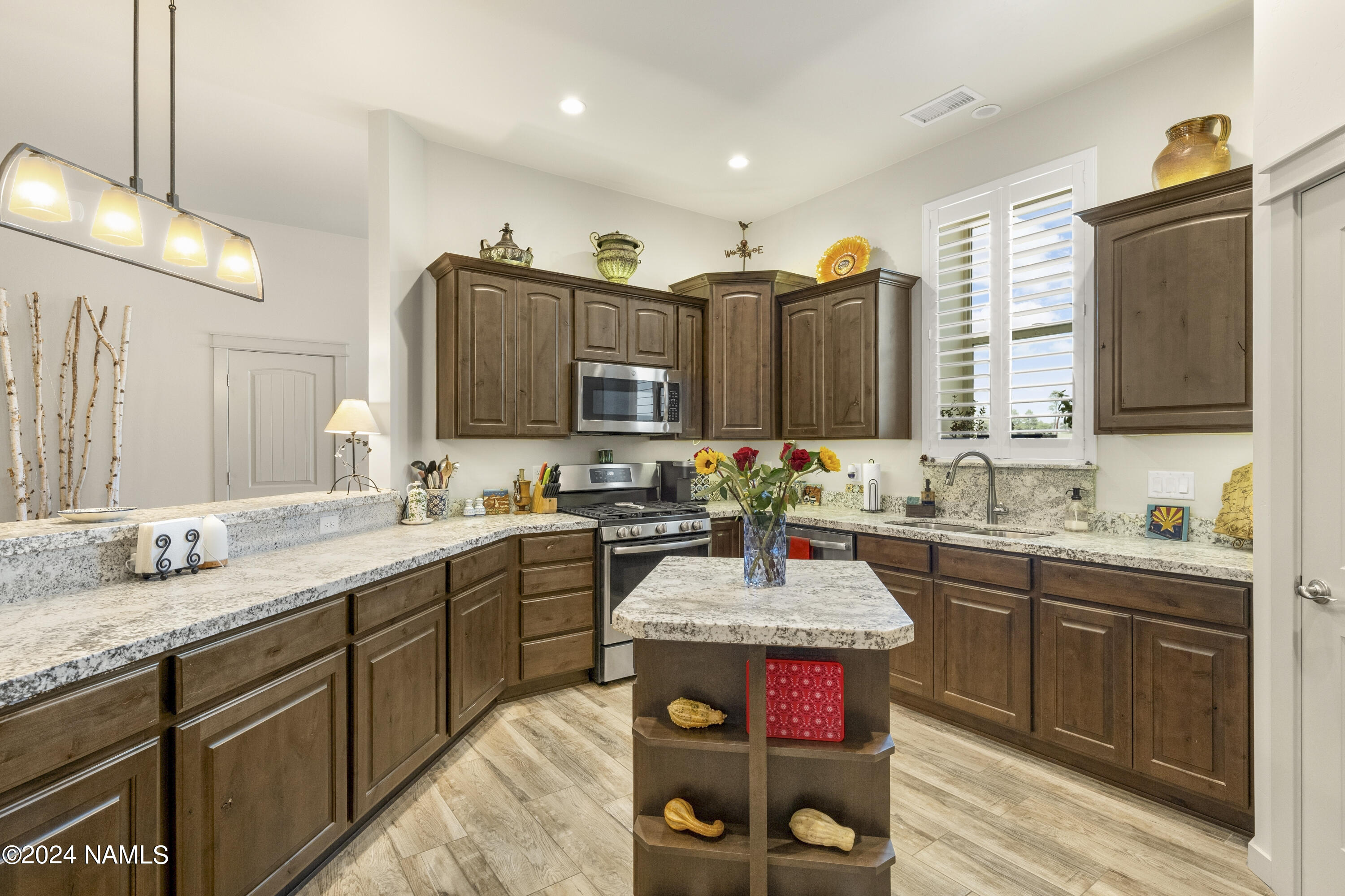 10290 Lundin Road Flagstaff, AZ 86004 - Photo 17 of 43 a spacious kitchen with stainless steel appliances granite countertop a sink and wooden cabinets