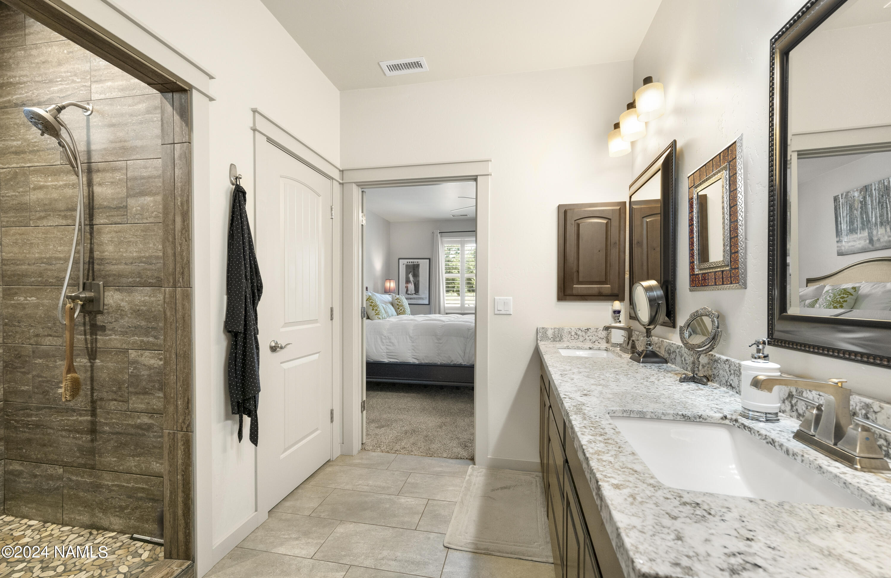 10290 Lundin Road Flagstaff, AZ 86004 - Photo 25 of 43 a en suite bathroom with a granite countertop double vanity and a mirror