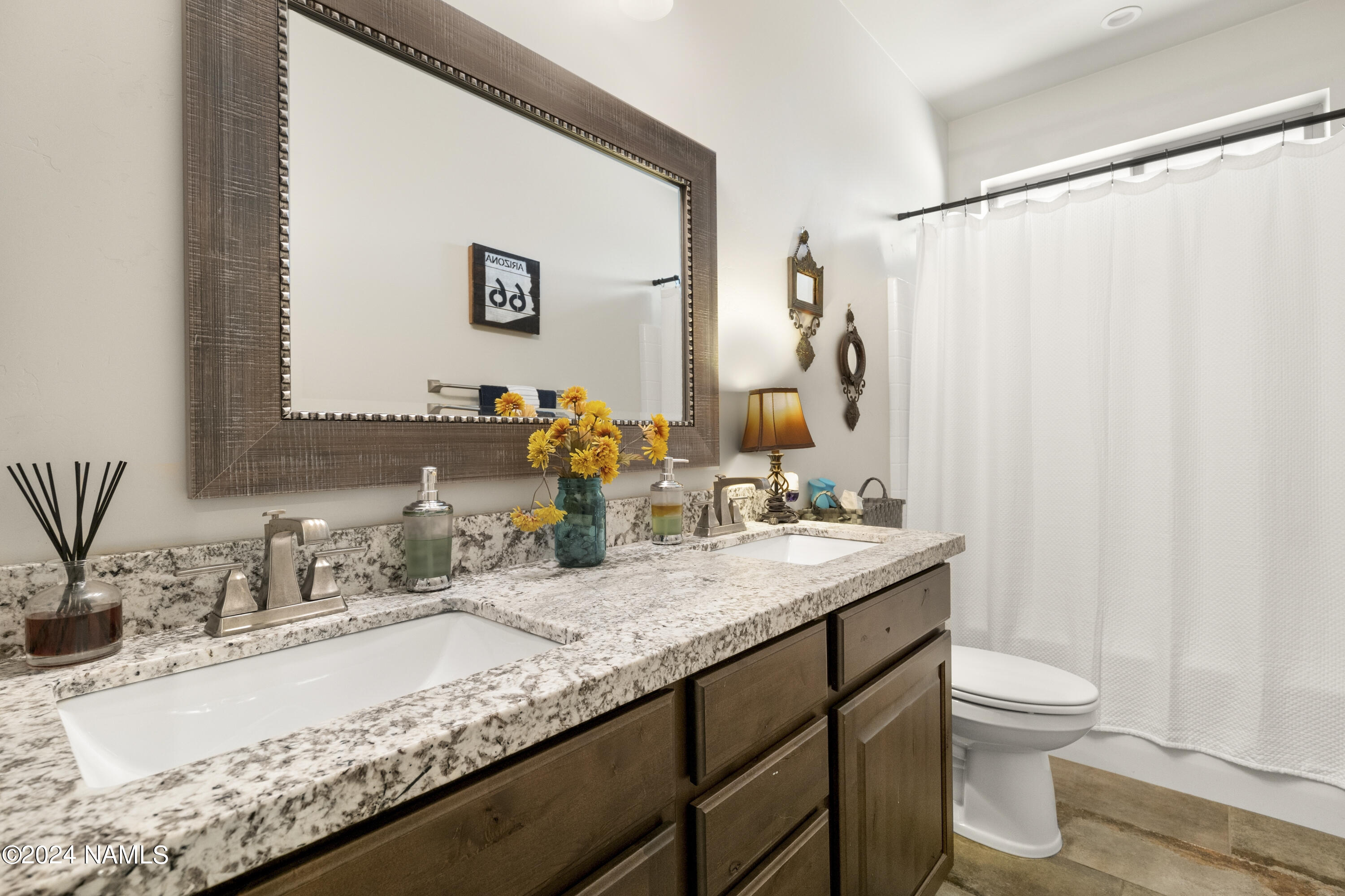 10290 Lundin Road Flagstaff, AZ 86004 - Photo 28 of 43 a bathroom with a granite countertop sink and a mirror