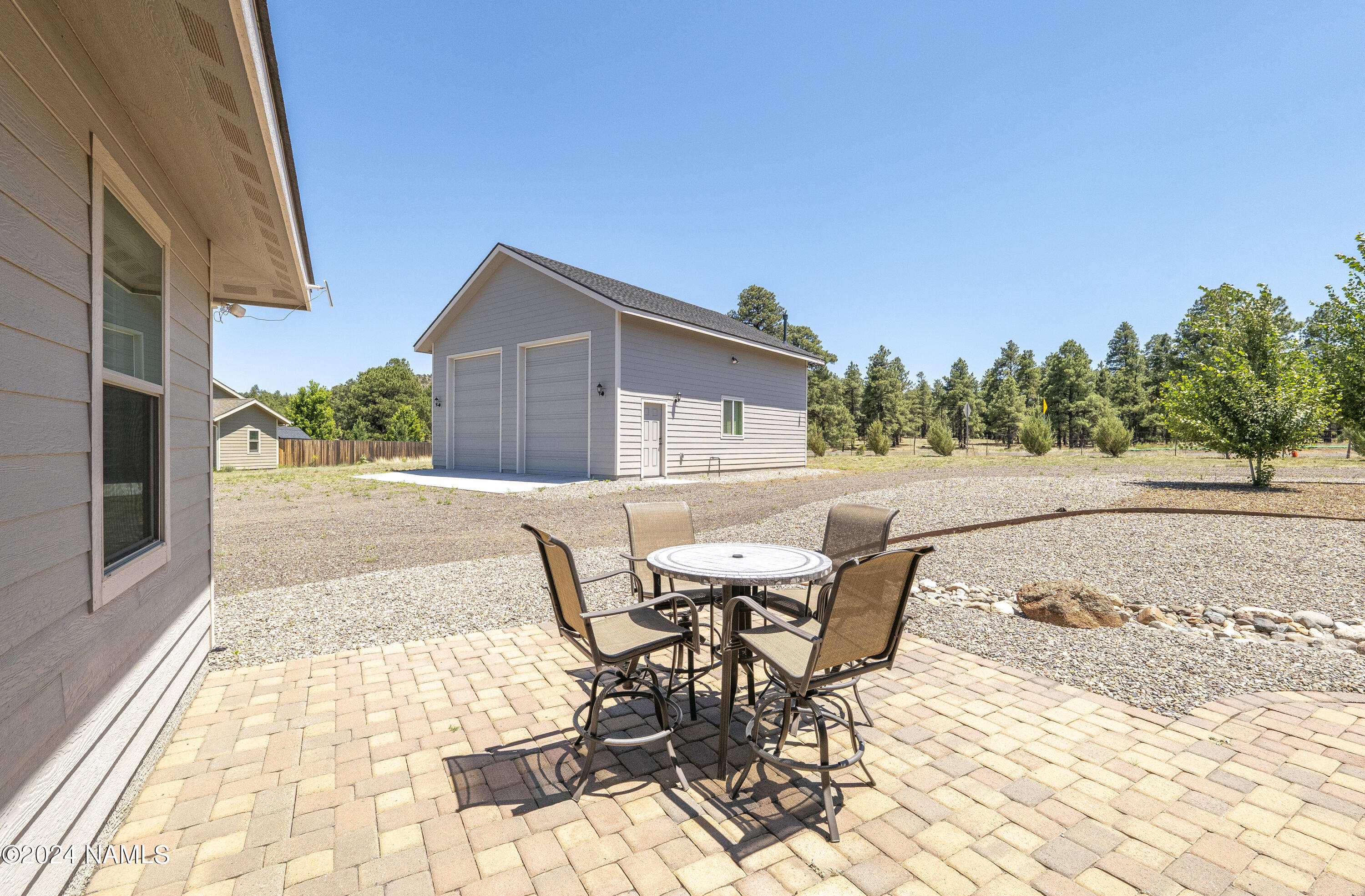 10290 Lundin Road Flagstaff, AZ 86004 - Photo 36 of 43 a view of a patio with table and chairs with wooden floor and fence