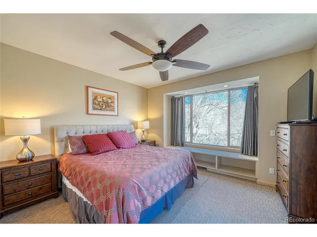 a bedroom with a bed and a flat tv screen on dresser