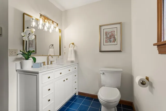 a bathroom with a toilet a sink and mirror