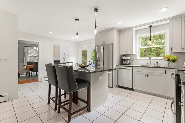 a kitchen with a dining table chairs cabinets and stainless steel appliances