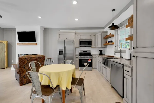 a kitchen with stainless steel appliances kitchen island granite countertop a sink and a refrigerator