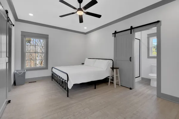a spacious bedroom with a bed and a chandelier