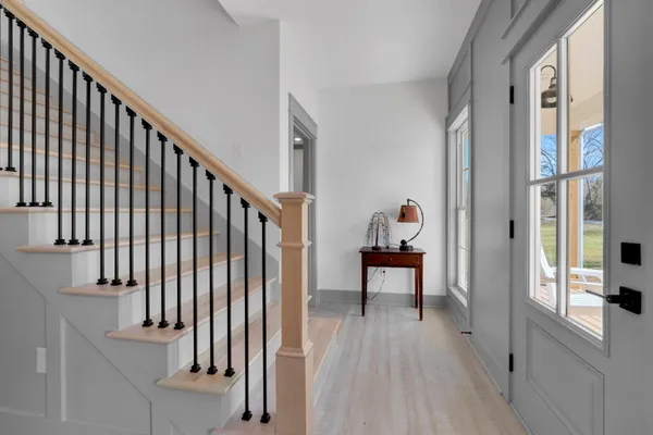 a view of a hallway with wooden floor and staircase