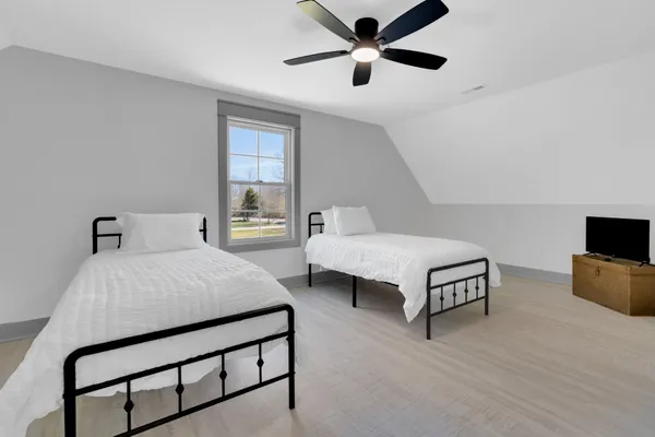 a bedroom with a bed a flat screen tv and dresser