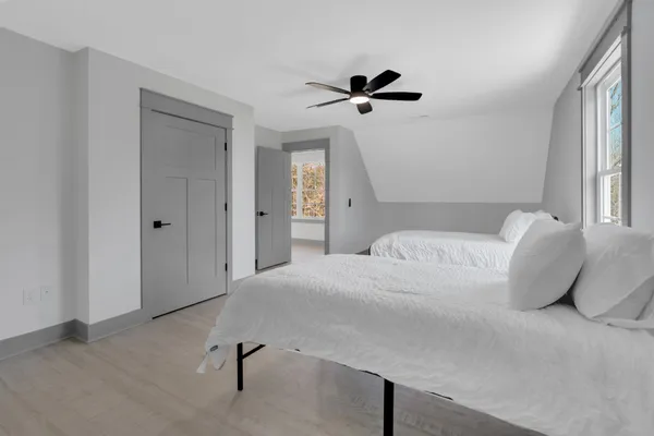 a bedroom with a large bed and a ceiling fan