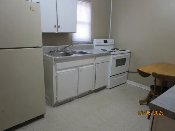 a kitchen with white cabinets and a sink