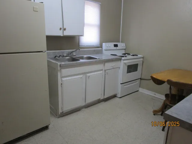 a kitchen with white cabinets and a sink