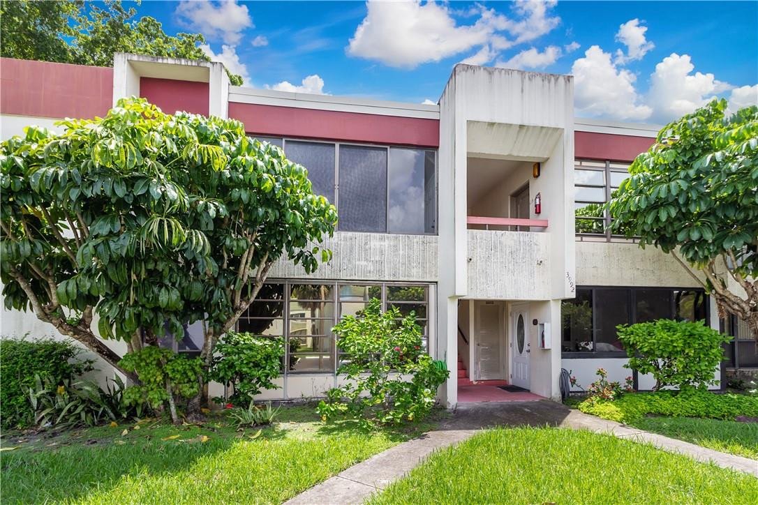 3992 North Pine Island Road, Unit 2A Sunrise, FL 33351 - Photo 16 of 18 a front view of a house with a garden and plants