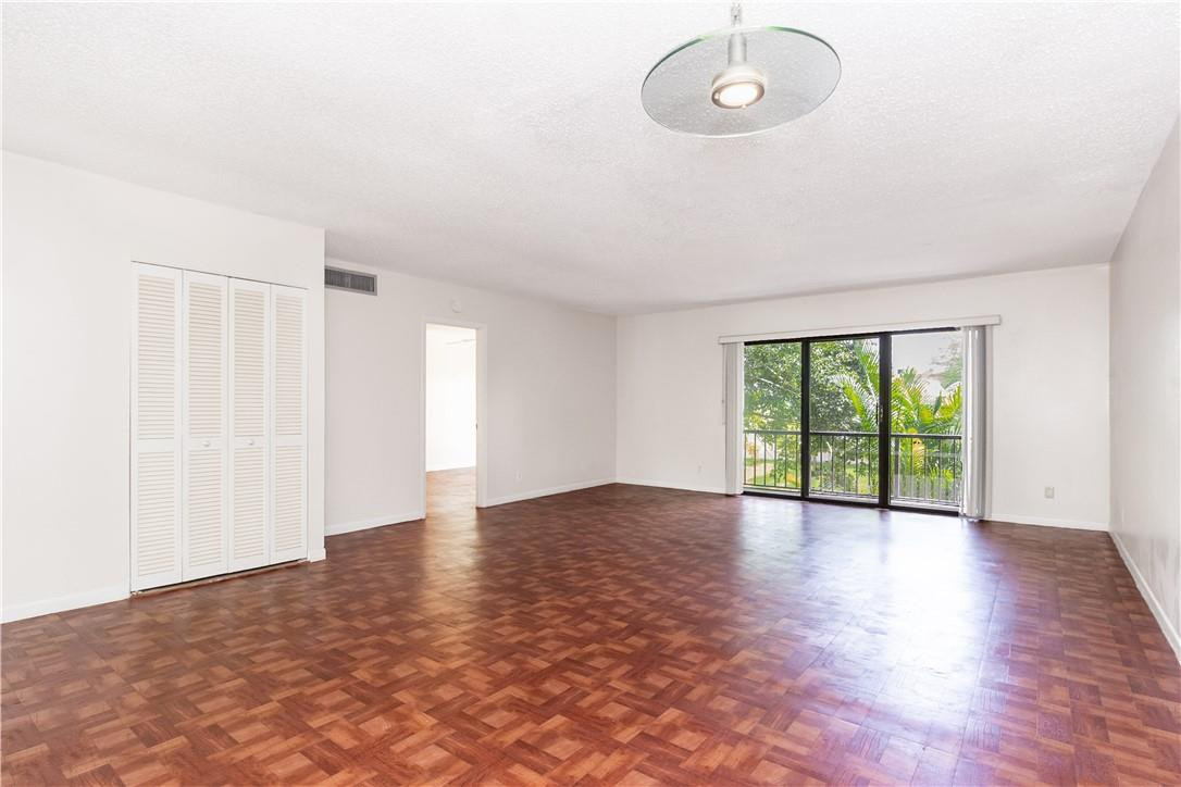 3992 North Pine Island Road, Unit 2A Sunrise, FL 33351 - Photo 4 of 18 a view of an empty room with wooden floor and a window