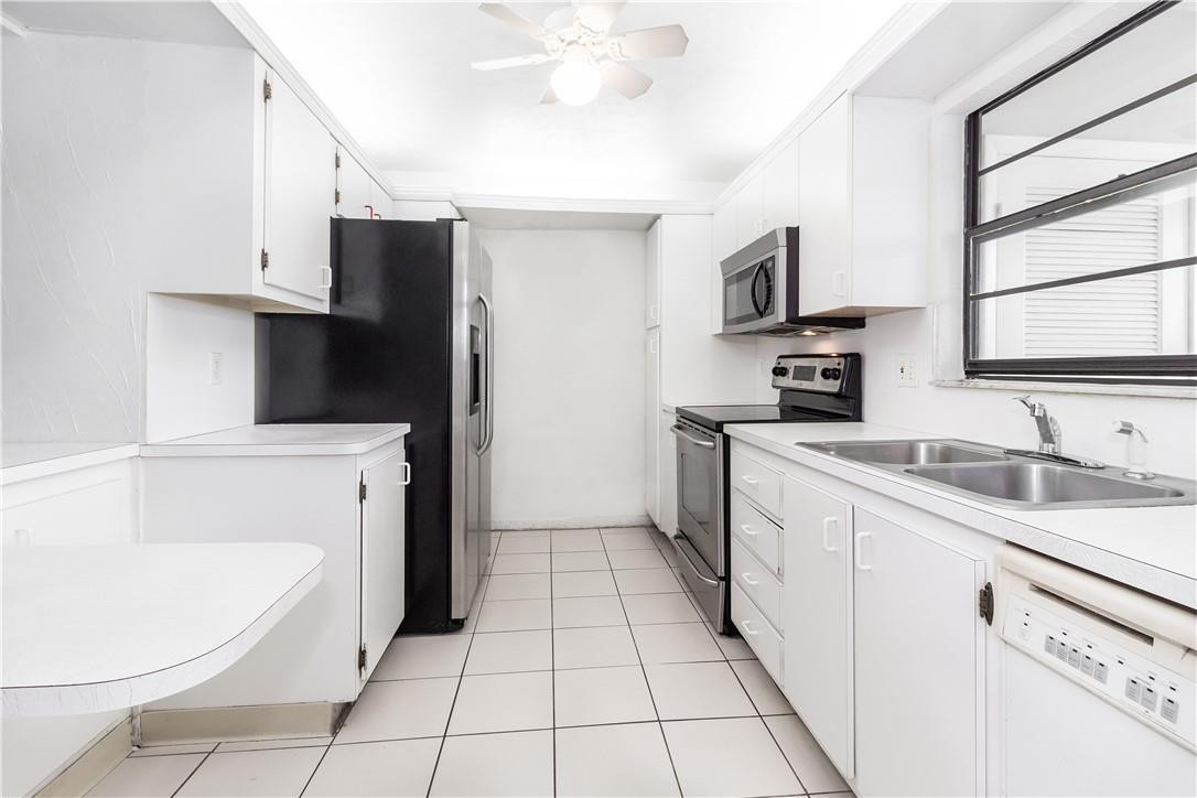 3992 North Pine Island Road, Unit 2A Sunrise, FL 33351 - Photo 5 of 18 a kitchen with a sink a stove and refrigerator