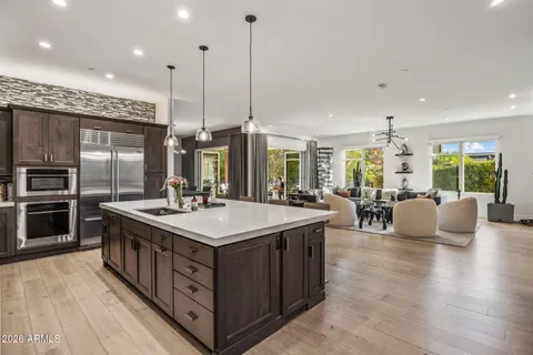 a kitchen with kitchen island a large counter top space a sink stainless steel appliances and a large window