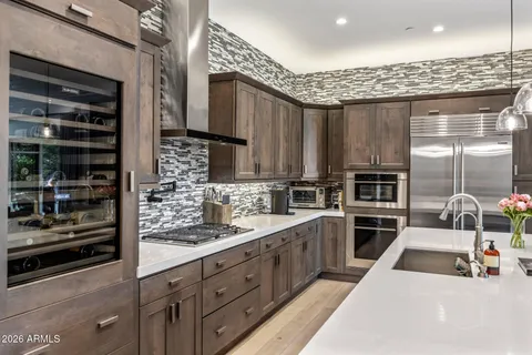 a kitchen with stainless steel appliances kitchen island granite countertop a sink stove and cabinets