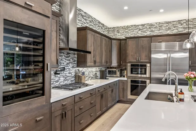a kitchen with stainless steel appliances kitchen island granite countertop a sink stove and cabinets
