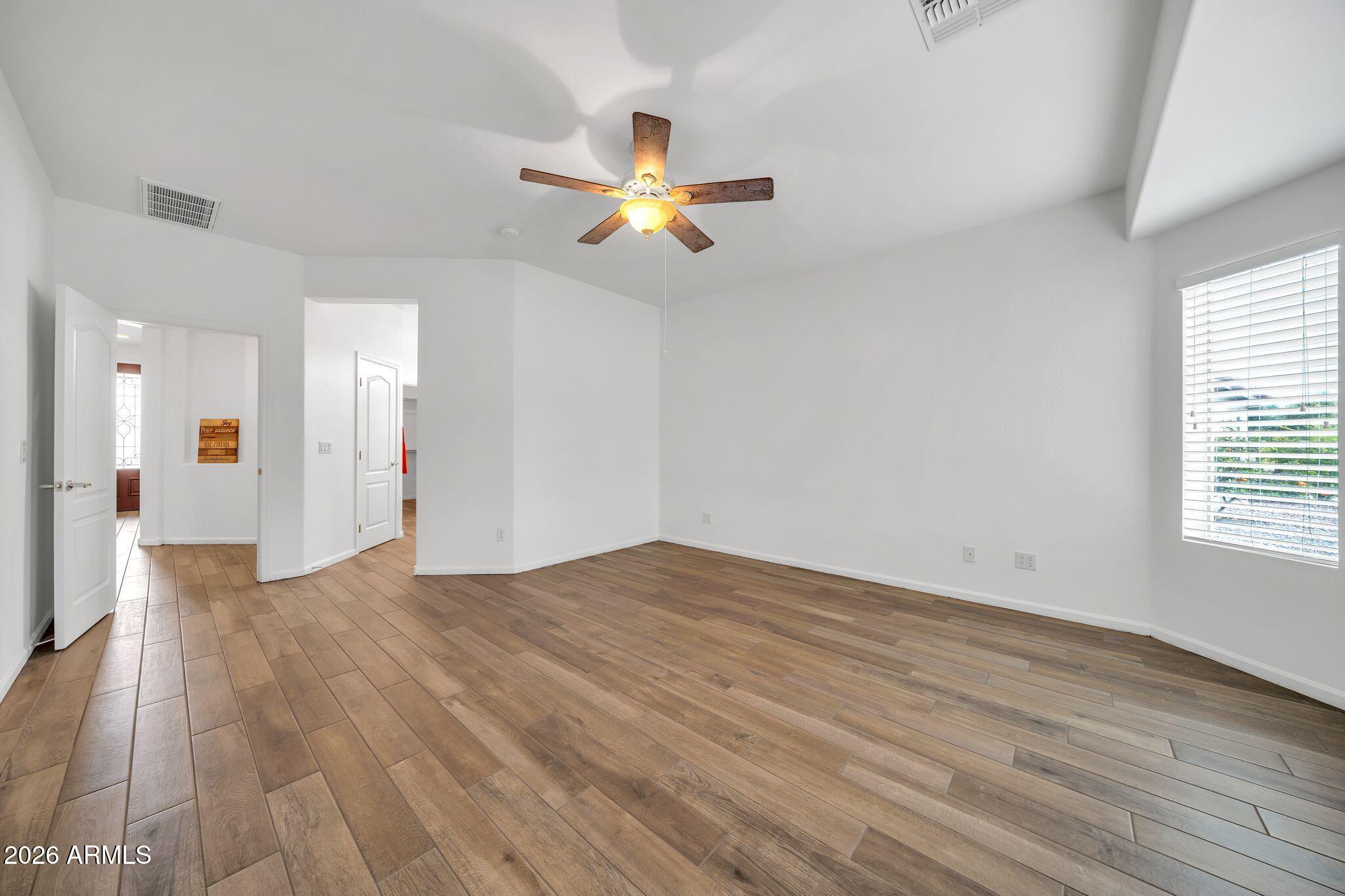 16435 West Berkeley Road Goodyear, AZ 85395 - Photo 24 of 52 a view of empty room with wooden floor and fan