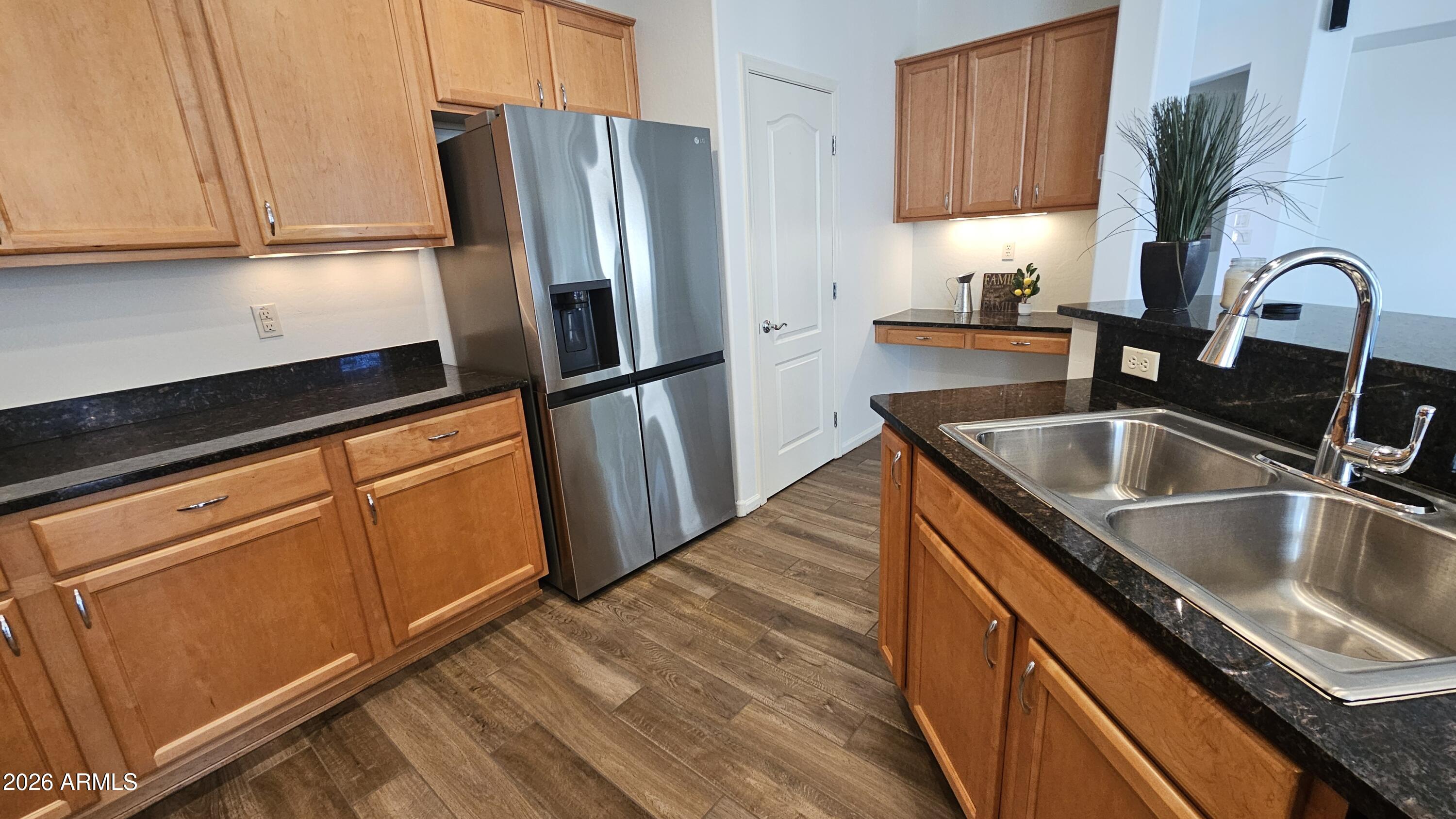 16435 West Berkeley Road Goodyear, AZ 85395 - Photo 6 of 52 a kitchen with stainless steel appliances granite countertop a refrigerator sink and cabinets