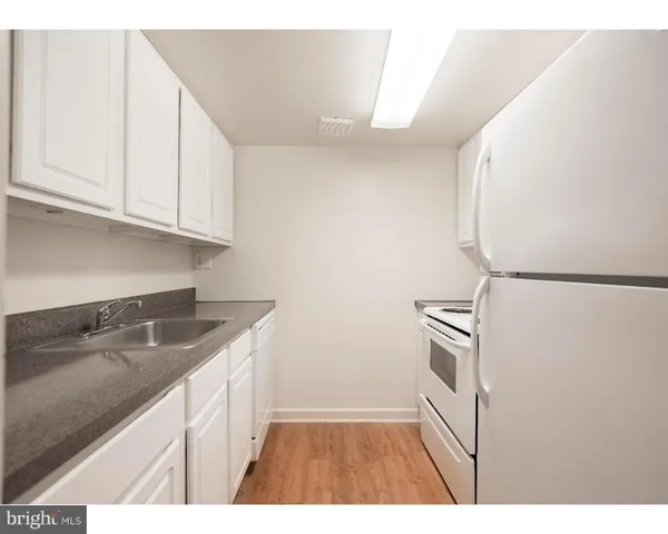 a kitchen with granite countertop a sink a stove and cabinets