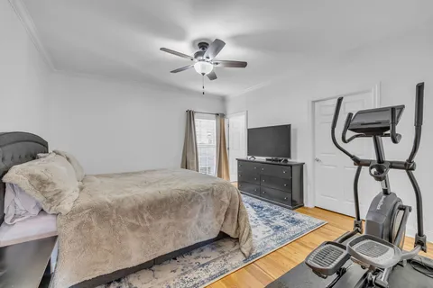 a bedroom with a bed and wooden floor