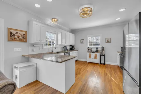 a kitchen with granite countertop a stove top oven sink and cabinets
