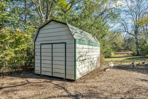 a backyard of a house with barbeque oven and outdoor seating