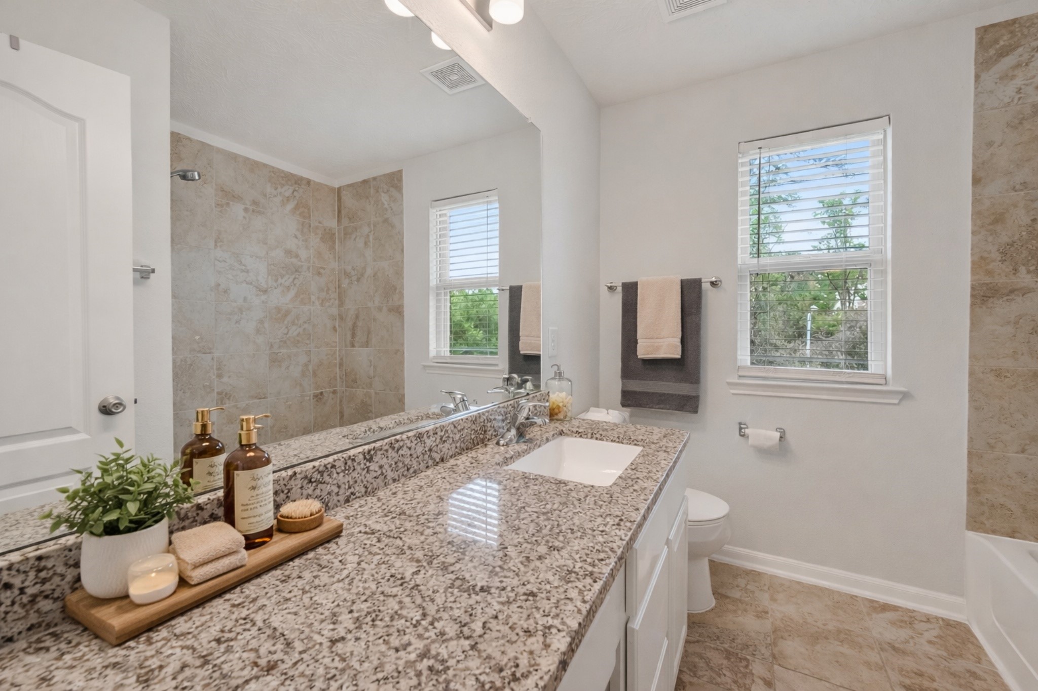 2107 Parnevik Place Conroe, TX 77304 - Photo 31 of 44 The Hall Bathroom features a granite countertop, single wash basin, and a combination tub/shower. digitally enhanced