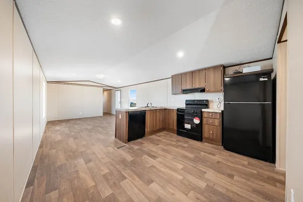 a kitchen with refrigerator cabinets and wooden floor