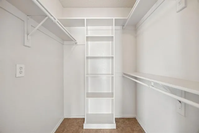 a view of walk in closet with empty racks