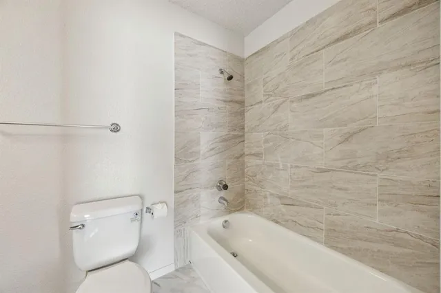 a bathroom with a toilet and bathtub