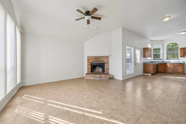 en empty room with windows and fireplace