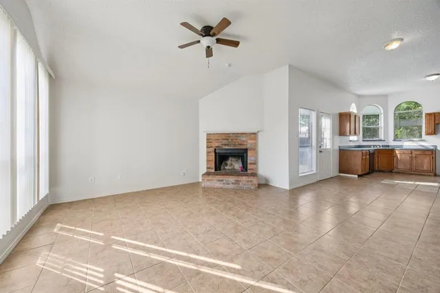 en empty room with windows and fireplace
