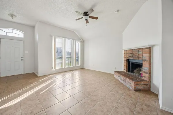 a view of an empty room with a fireplace and a window
